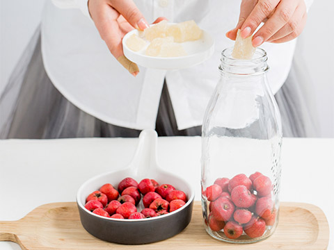 Remove the berry stalks before placing them in a dry and air-tight jar; place a layer of yellow crystal sugar on top.